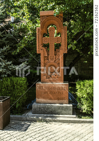 Khachkar with a cross in a figured arch and figures of birds and deer in the Park near the Zoravar Church in the center of Yerevan 72162562