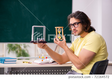 Young male student physicist preparing for exams in the classroo 72164572