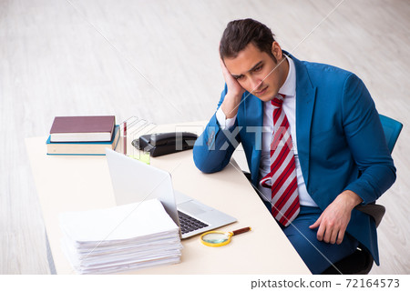 Young male employee working in the office 72164573