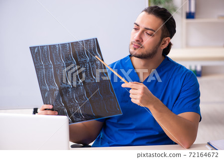 Young male doctor teacher radiologist in front of whiteboard 72164672