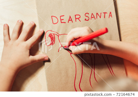 Childs hands drawing letter to Santa close up 72164674