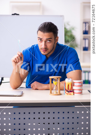 Young male doctor teacher dentist in front of whiteboard 72164675