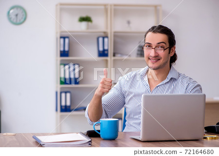 Young male bookkeeper working in the office 72164680