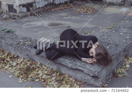 the girl driven into a corner in fear stands and looks the girl driven into a corner in fear stands and looks 72164802