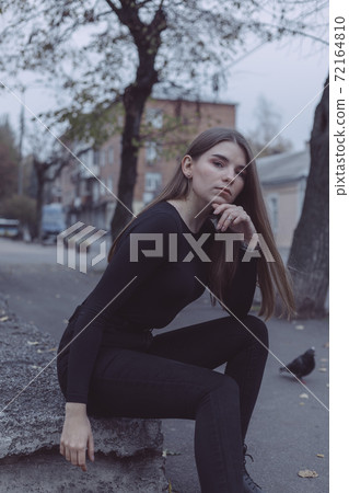 young girl sitting and looking at the background of the ruined Soviet young girl sitting and looking at the background of the ruined Soviet 72164810
