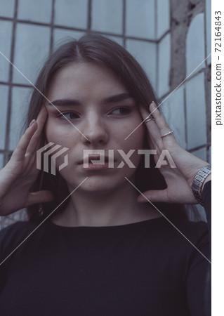 the girl driven into a corner in fear stands and looks 72164843