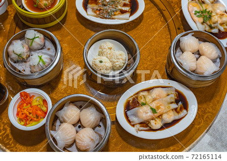 Assortment of delicious dimsum dumplings and rice rolls on table 72165114