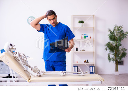Young male radiologist doctor and skeleton patient 72165411