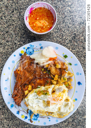 Plate of tasty Vietnamese homemade pork chop rice on table 72165426