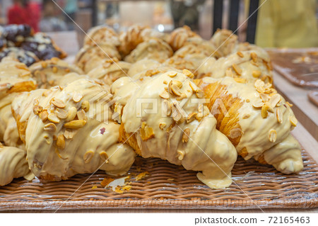 Pile of delicious croissants topped with cream cheese and peanuts Pile of delicious croissants topped with cream cheese and peanuts 72165463