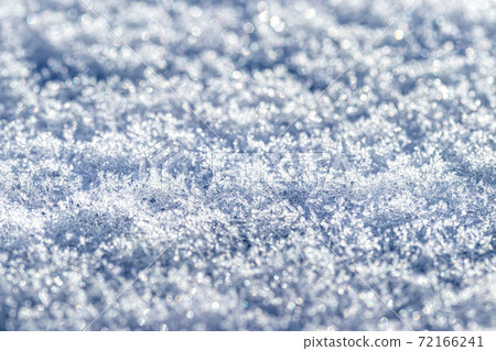 Snow crystals illuminated by sunlight. Winter background. 72166241