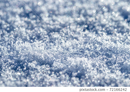 Snow crystals illuminated by sunlight. Winter background. 72166242