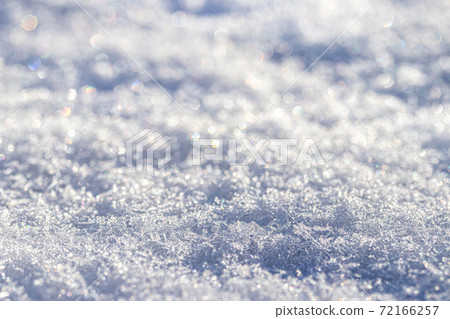 Snow crystals illuminated by sunlight. Winter background. 72166257