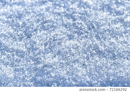 Top view of snow crystals illuminated by sunlight. Winter background. 72166292