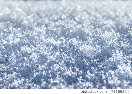 Snow crystals illuminated by sunlight. Winter background. 72166294