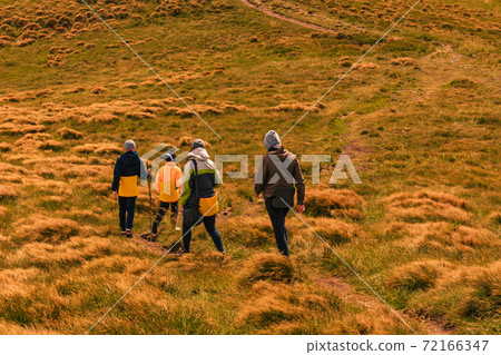 Tourists follow a mountain trail on a tourist sign to the next destination. 72166347