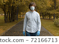 Man in mask walking in the park 72166713