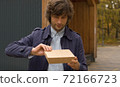 Man opening a disposable lunch box 72166723