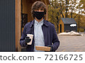 A man comes out of a fast food restaurant 72166725
