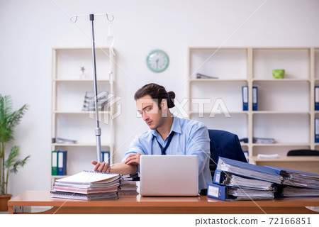 Young male employee suffering at workplace Young male employee suffering at workplace 72166851