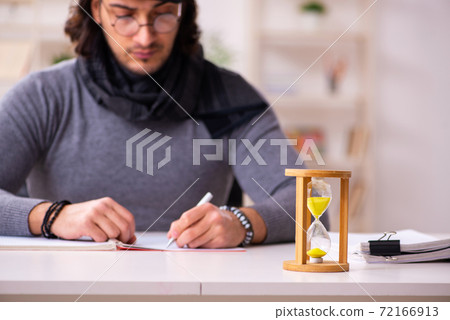 Young male writer in time management concept Young male writer in time management concept 72166913