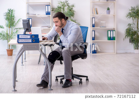 Young leg injured employee working in the office Young leg injured employee working in the office 72167112