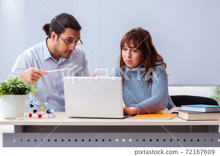 Young female student and male teacher in the classroom Young female student and male teacher in the classroom 72167609