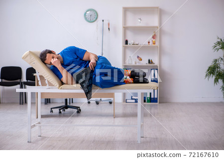 Young male doctor radiologist being unhappy after night shift 72167610