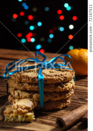 New Year's Christmas oatmeal cookies, beautifully tied with a blue ribbon, close-up. Homemade cakes, gift, packaging. New Year's Christmas oatmeal cookies, beautifully tied with a blue ribbon, close-up. Homemade cakes, gift, packaging. 72167811