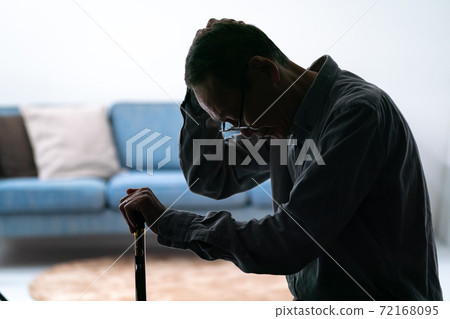 一個老人抱著拐杖的剪影 72168095