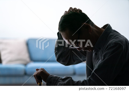 Silhouette of a senior man worried about holding a cane 72168097