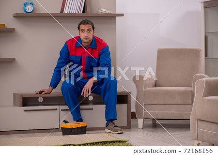 Young male contractor repairing furniture indoors 72168156