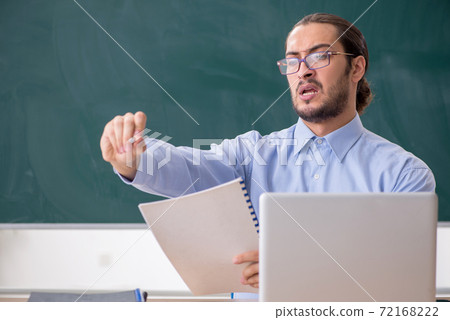 Young male teacher in the classroom in tele-education concept 72168222