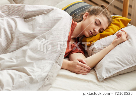 Woman sleeping in bed 72168523