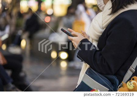 High school girl with a muffler to operate a smartphone High school girl with a muffler to operate a smartphone 72169319