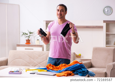 Young male tailor sewing masks at home during pandemic Young male tailor sewing masks at home during pandemic 72169587