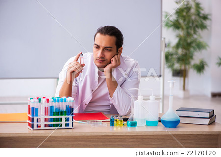 Young male chemistry teacher in the classroom Young male chemistry teacher in the classroom 72170120