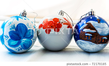 Handmade Christmas glass balls. Painted with a brush and acrylic paints. Decoration for the New year. Interior. Three balls on a light background 72170185