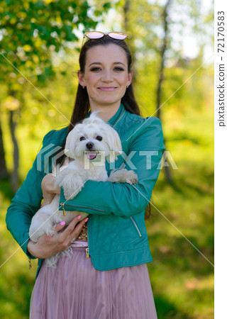 Puppy white dog with it's owner. Concept about friendship, animal and freedom. Puppy white dog with it's owner. Concept about friendship, animal and freedom. 72170583