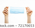 hands holding a mask, protective respiratory mask from the spread of the virus, on a white background 72170653