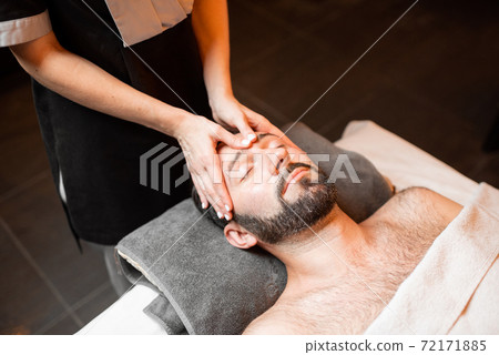 Man receiving facial massage at Spa salon Man receiving facial massage at Spa salon 72171885