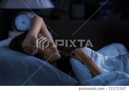 Depressed young woman lying in bed cannot sleep from insomnia 72172187