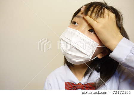 一個身體不適的女孩,戴著口罩,咳嗽,擠壓,發燒 一個身體不適的女孩,戴著口罩,咳嗽,擠壓,發燒 72172195