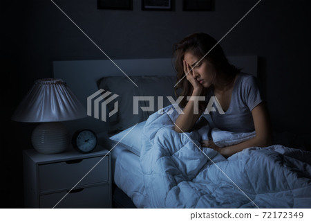 Depressed young Asian woman sitting in bed cannot sleep from insomnia. 72172349