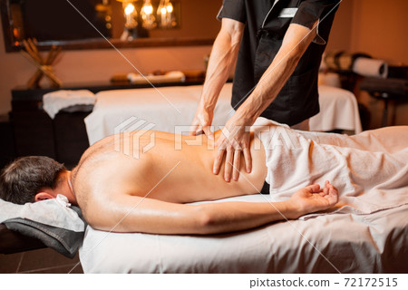 Man receiving a deep massage Man receiving a deep massage 72172515