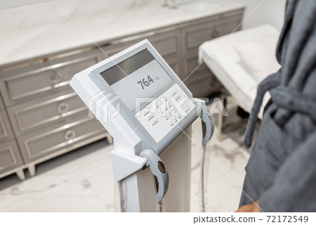 Woman measuring body composition balance, close-up 72172549