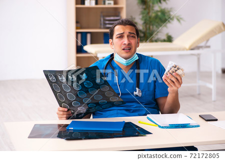 Young male doctor committing suicide at workplace 72172805