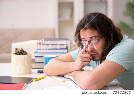 Young male student preparing for exams at home 72172807