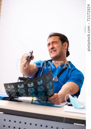 Young male doctor committing suicide at workplace Young male doctor committing suicide at workplace 72172824