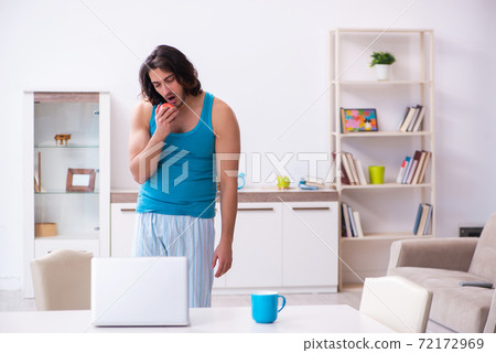 Young man waking up at home Young man waking up at home 72172969